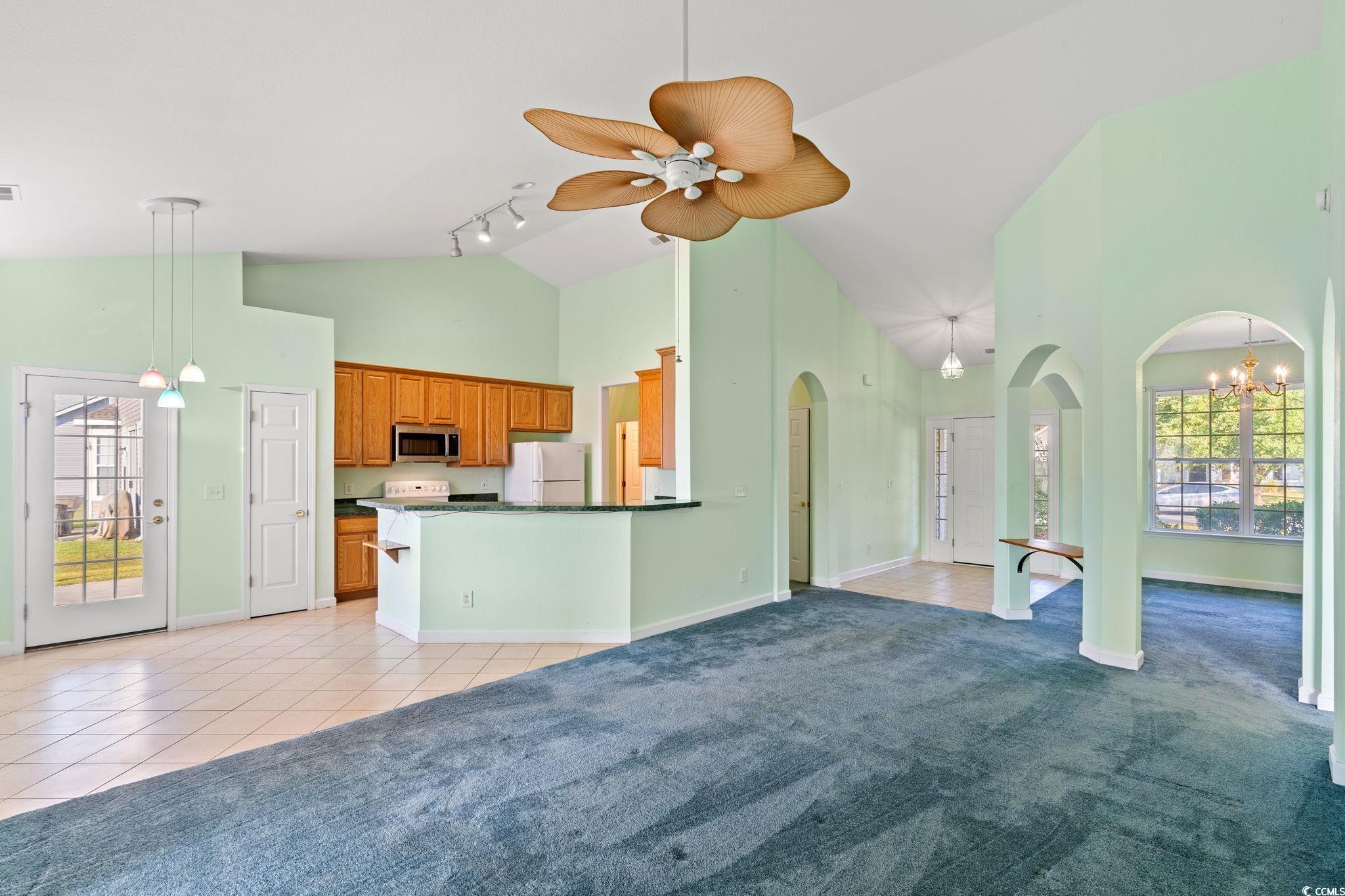875 Brookline Drive Myrtle Beach, SC 29579 - Photo 8 of 40 Kitchen with plenty of natural light, high vaulted ceiling, light tile patterned floors, and brown cabinetry