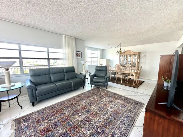 a living room with furniture fireplace and a large window