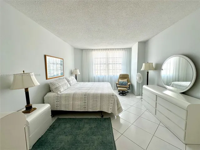a bathroom with a granite countertop sink a toilet a mirror and shower