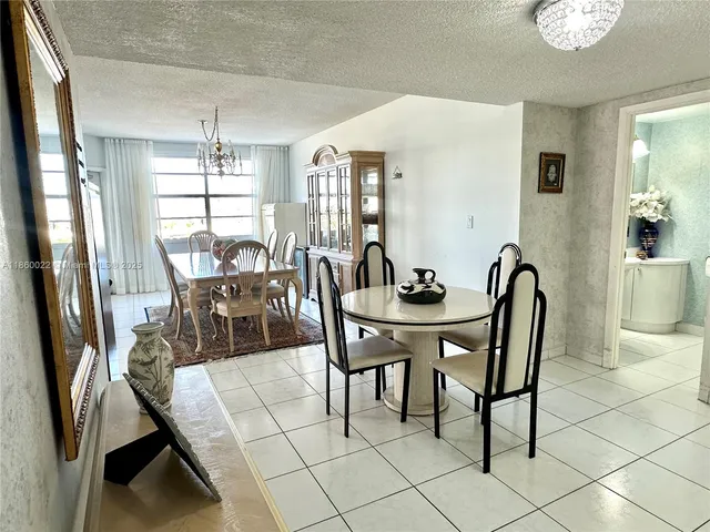 a living room with furniture a chandelier and a dining table with wooden floor