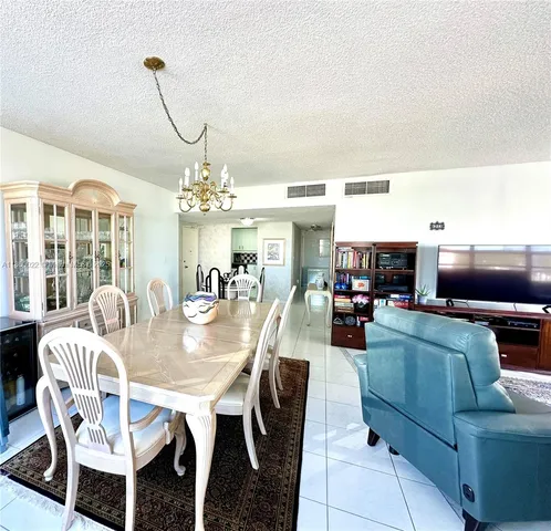 a living room with furniture a piano and a bookshelf