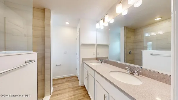 a bathroom with a double vanity sink a mirror and a shower
