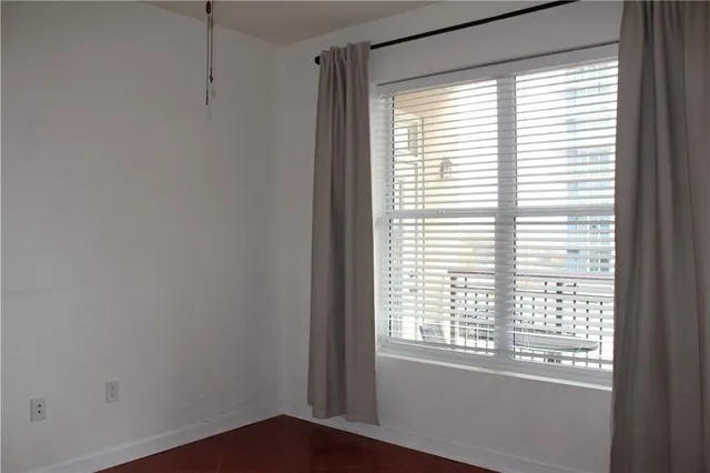 a view of a small space with wooden floor and a window