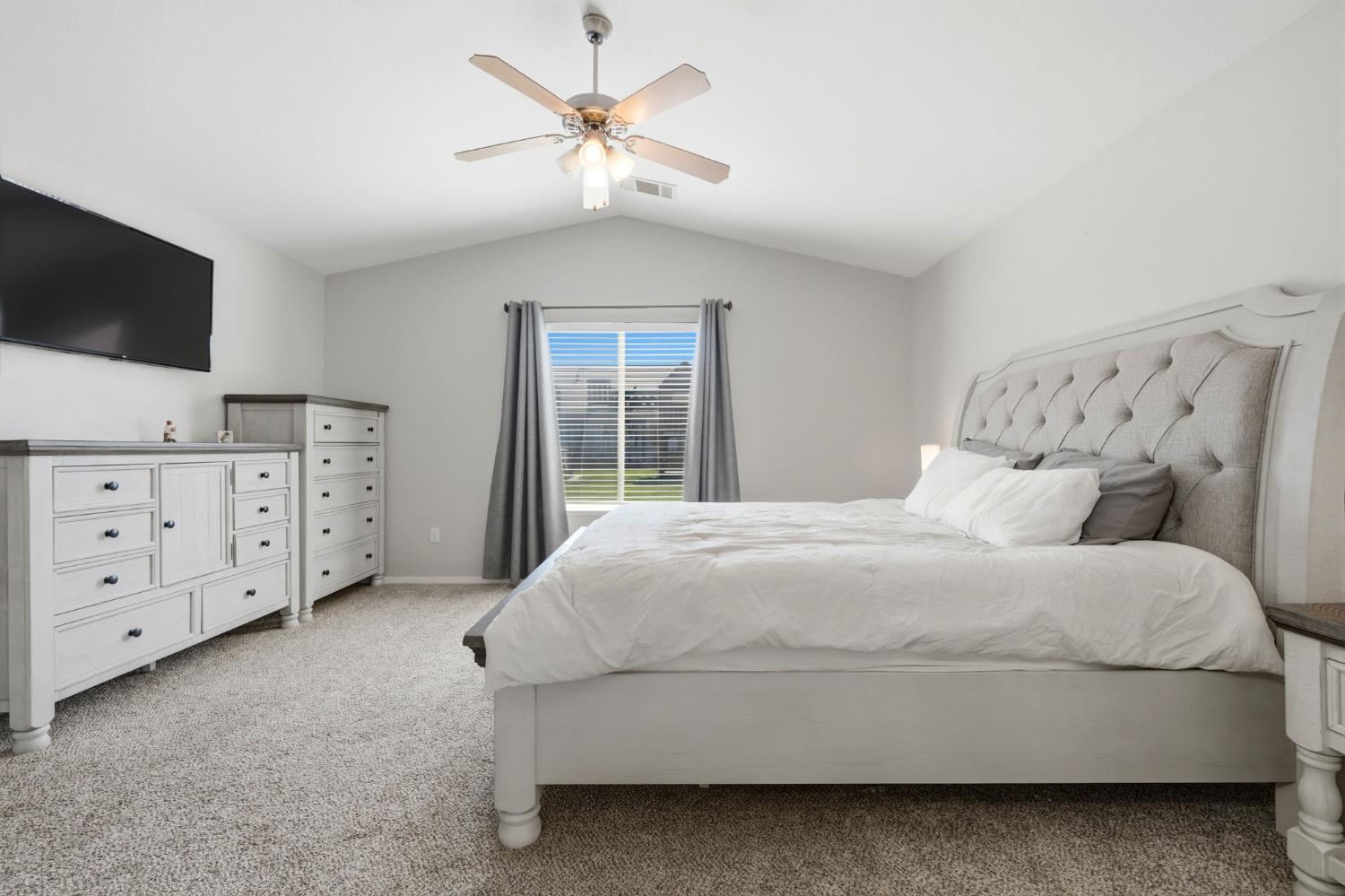 1849 West Spring Crest Street Hanford, CA 93230 - Photo 34 of 45 a spacious bedroom with a bed a dresser and a flat screen tv