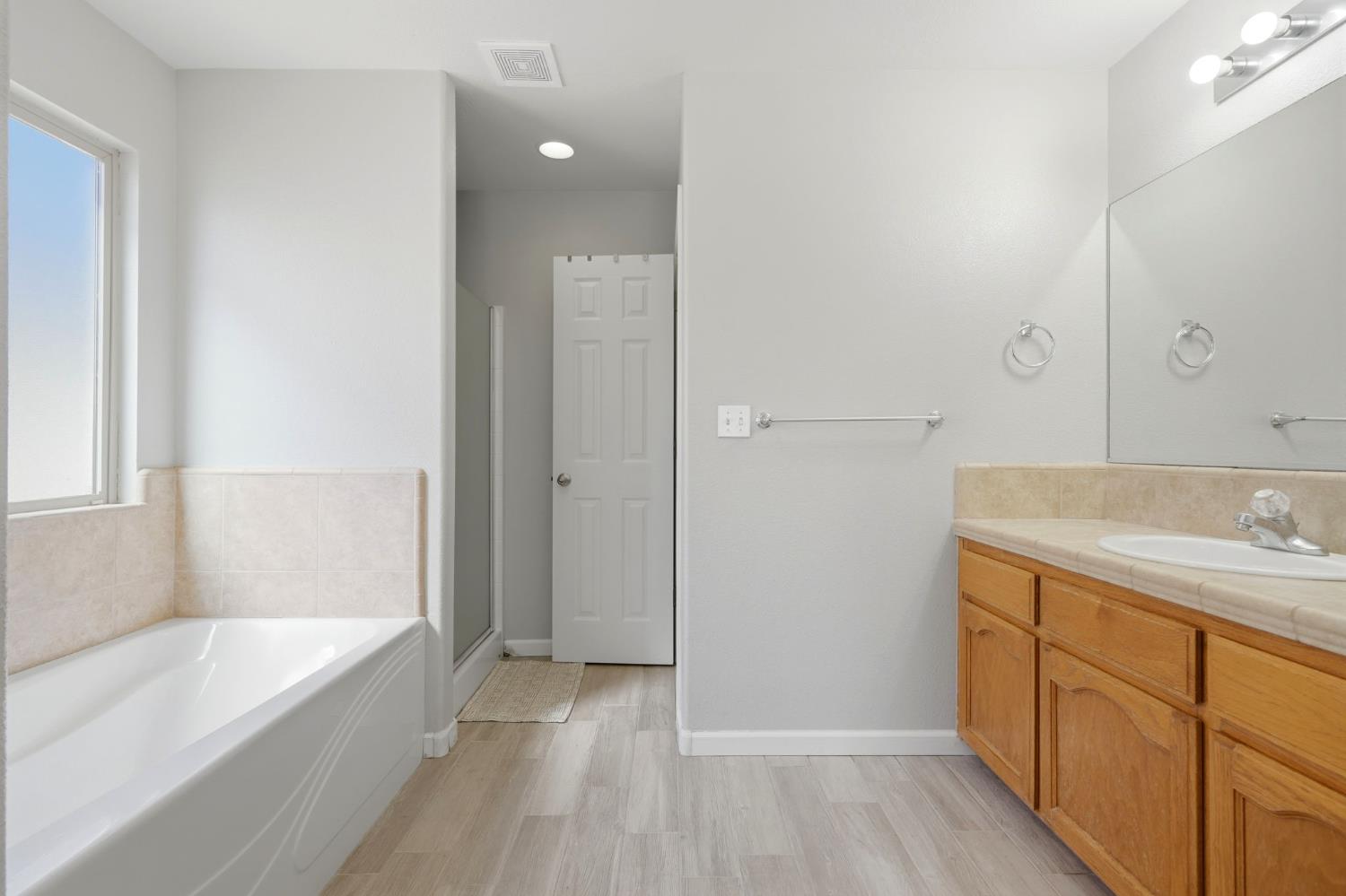 1849 West Spring Crest Street Hanford, CA 93230 - Photo 35 of 45 a bathroom with a tub sink and mirror