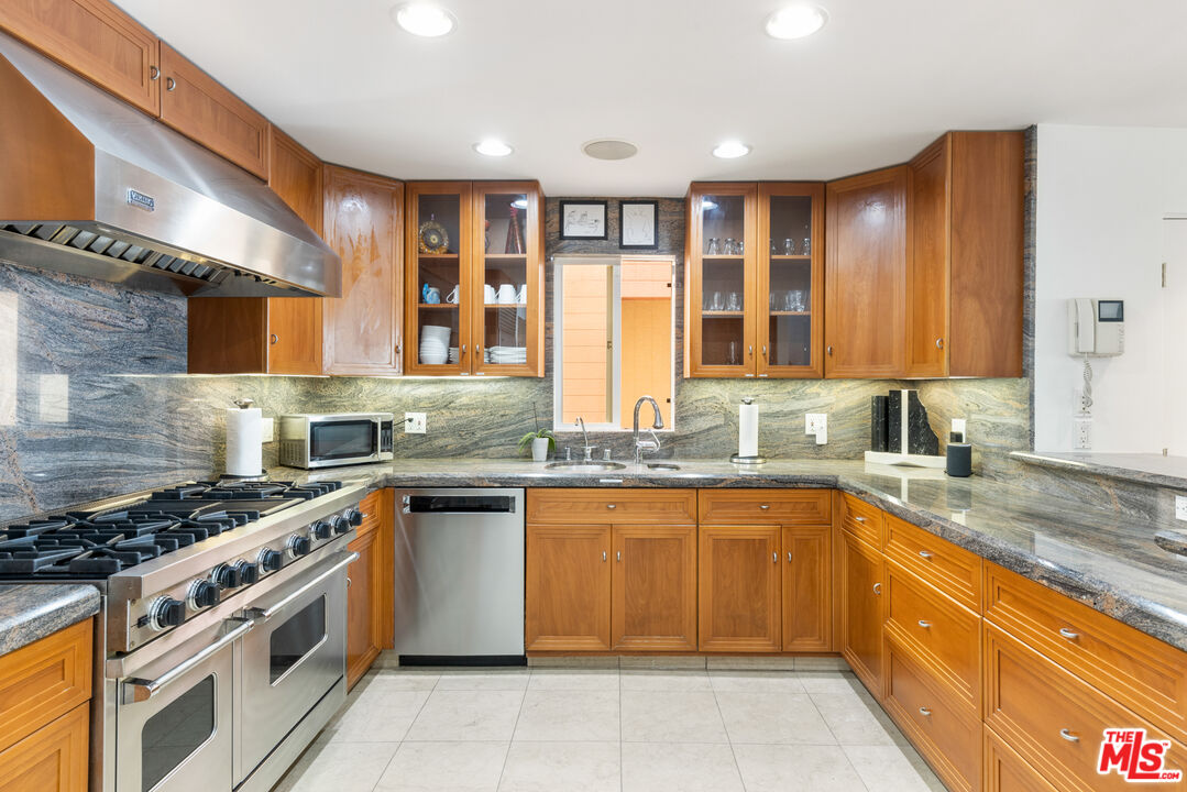 20520 Pacific Coast Highway Malibu, CA 90265 - Photo 11 of 27 a kitchen with stainless steel appliances granite countertop a stove sink and cabinets