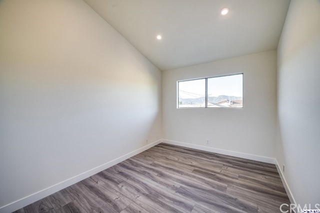 1050 Spazier Avenue, Unit 5 Glendale, CA 91201 - Photo 17 of 27 an empty room with wooden floor and windows
