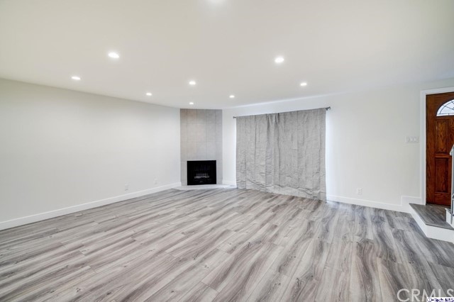 1050 Spazier Avenue, Unit 5 Glendale, CA 91201 - Photo 2 of 27 a view of an empty room with wooden floor and a window