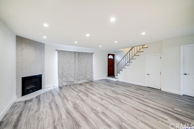 1050 Spazier Avenue, Unit 5 Glendale, CA 91201 - Photo 3 of 27 a view of empty room with wooden floor and fireplace