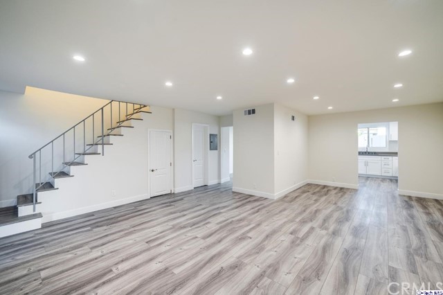 1050 Spazier Avenue, Unit 5 Glendale, CA 91201 - Photo 4 of 27 a view of an empty room with wooden floor and stairs