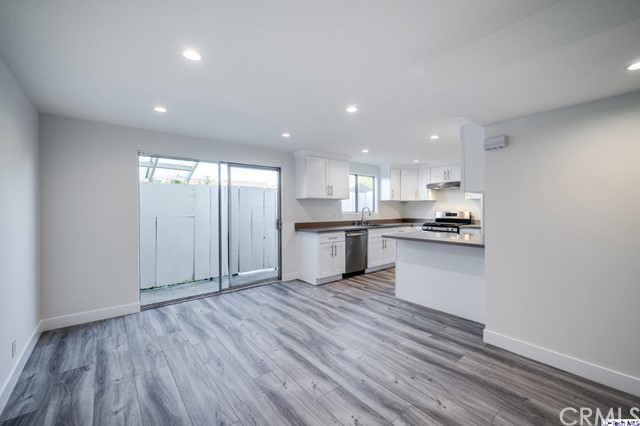 1050 Spazier Avenue, Unit 5 Glendale, CA 91201 - Photo 6 of 27 a kitchen with a refrigerator and white cabinets