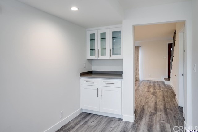 1050 Spazier Avenue, Unit 5 Glendale, CA 91201 - Photo 8 of 27 a kitchen with a wooden floor and white cabinets