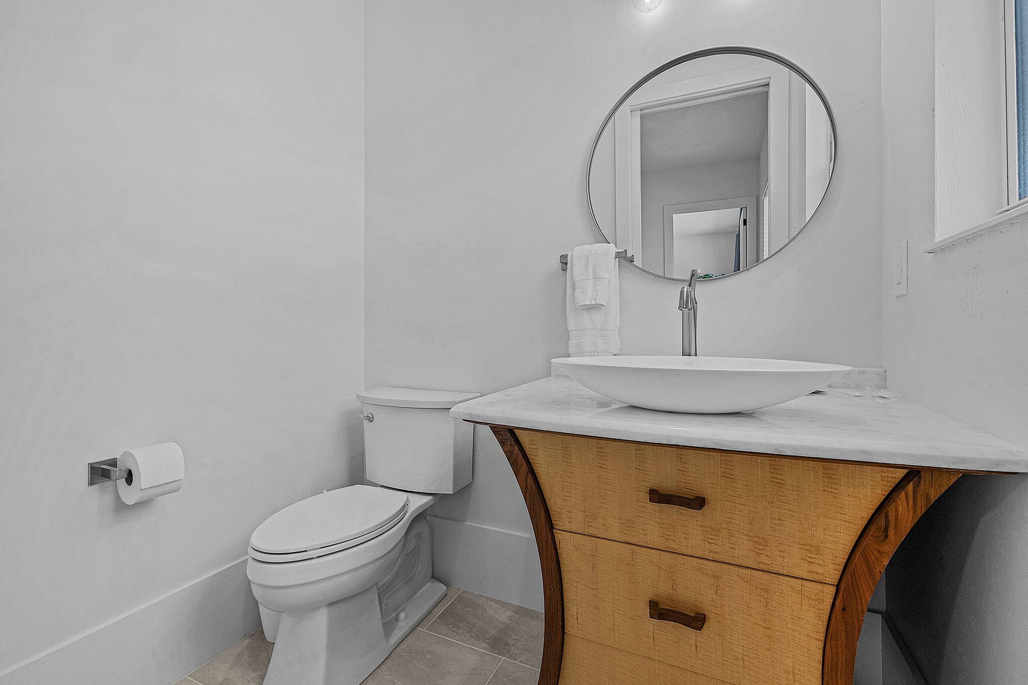 2499 Pine Street Naples, FL 34112 - Photo 15 of 18 a bathroom with a sink a toilet and a mirror