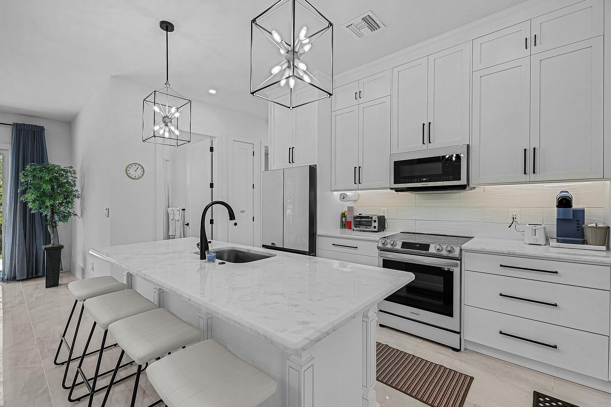 2499 Pine Street Naples, FL 34112 - Photo 5 of 18 a kitchen with stainless steel appliances a table chairs and cabinets
