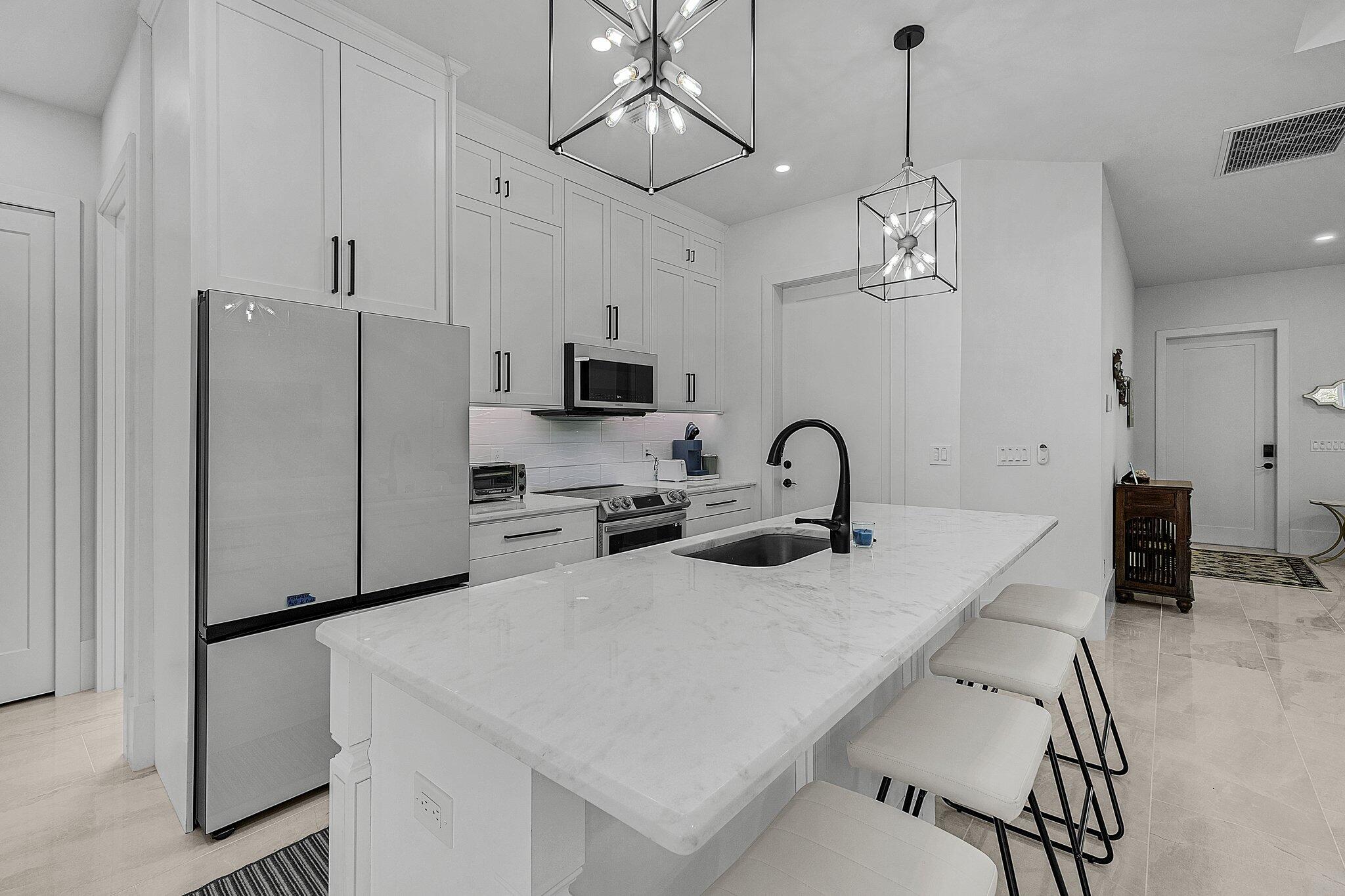 2499 Pine Street Naples, FL 34112 - Photo 6 of 18 a kitchen with stainless steel appliances granite countertop a sink a stove a refrigerator and cabinets