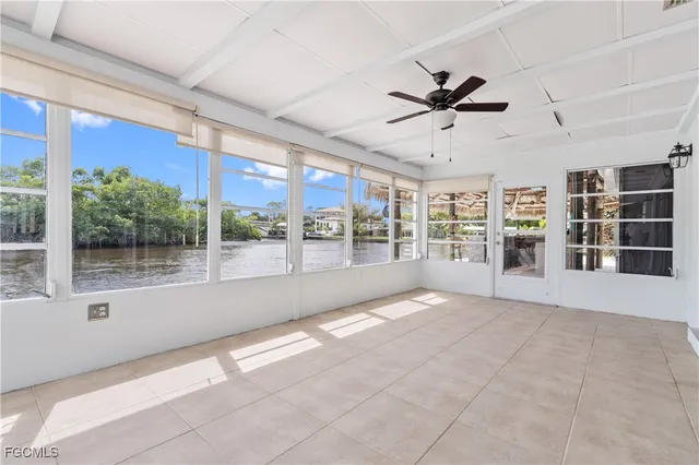 a view of an empty room with a window and kitchen view