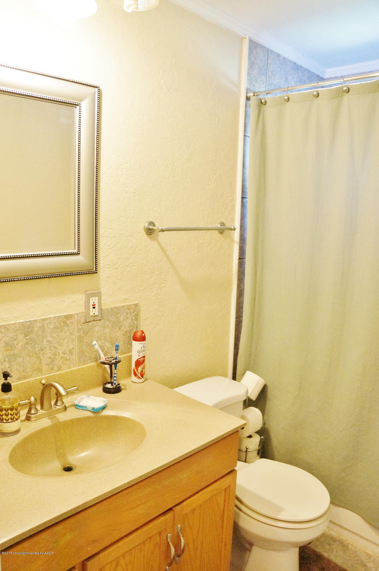 4207 Bowie Street Amarillo, TX 79110 - Photo 7 of 11 a bathroom with a sink a toilet and mirror