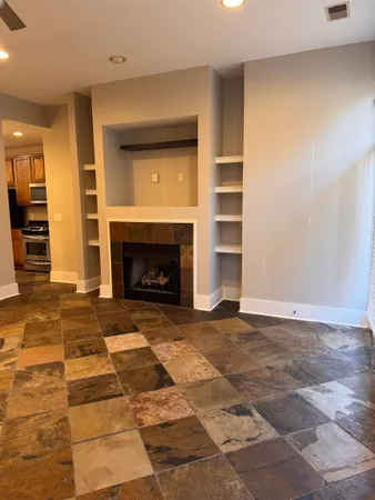 a view of empty room with a fireplace and window