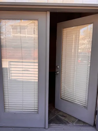 a view of an empty room with window and chandelier fan