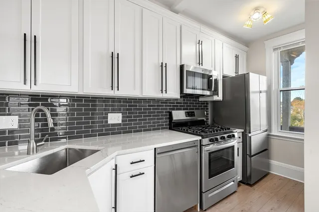 a kitchen with granite countertop a sink stove and refrigerator