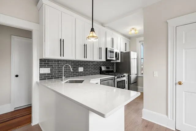 a kitchen with stainless steel appliances a sink stove and refrigerator