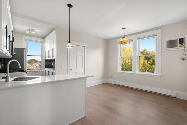 a kitchen with a stove cabinets and a wooden floor