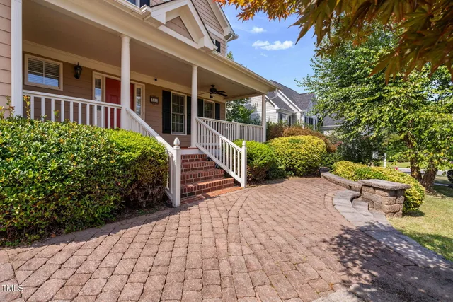 an empty room with chandelier fan and windows