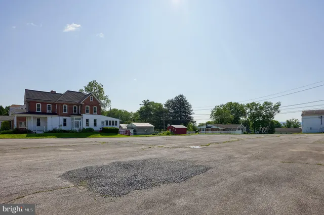 a front view of a house with a yard and trees