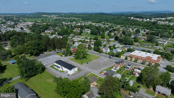 an aerial view of residential houses with outdoor space and trees