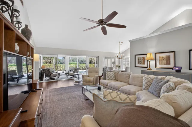 a living room with furniture a dining table and a chandelier