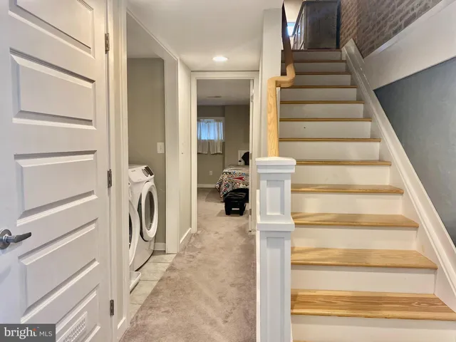 a view of a water heater and a room with wooden floor