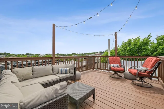 a roof deck with couches and wooden floor