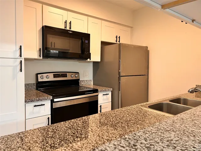 a kitchen with stainless steel appliances granite countertop a refrigerator stove and microwave