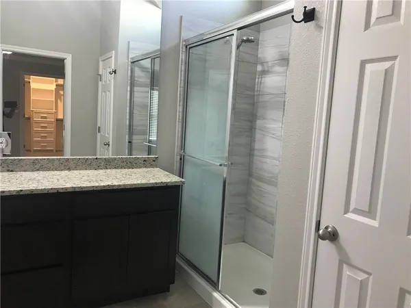 a bathroom with a glass shower door