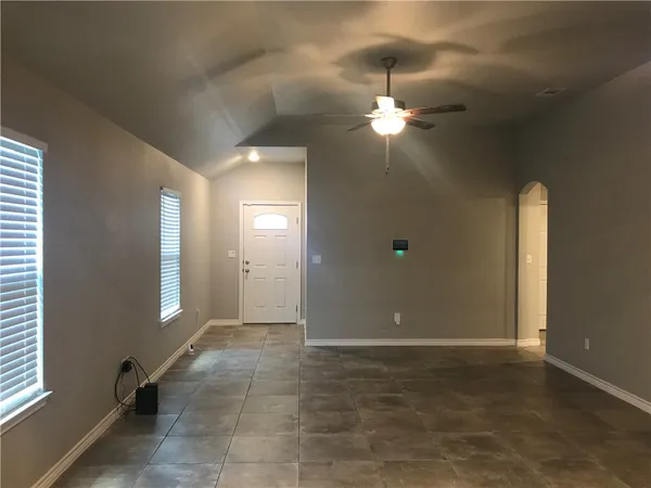 an empty room with stairs and wooden floor