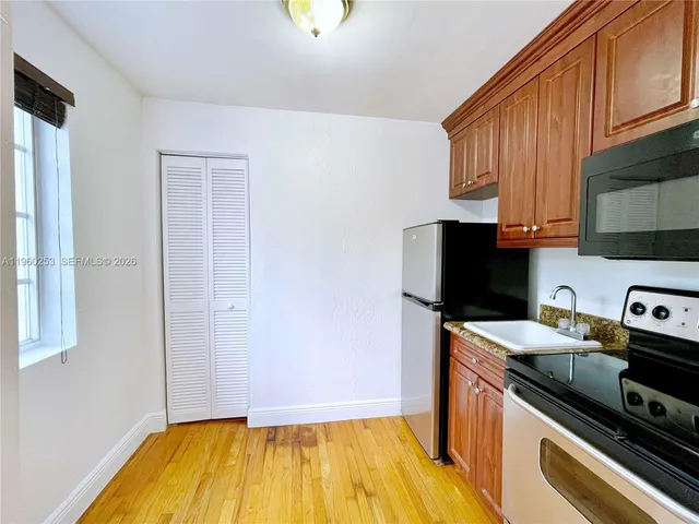 a kitchen with a sink a stove and cabinets