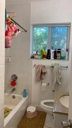 a bathroom with a sink toilet and window