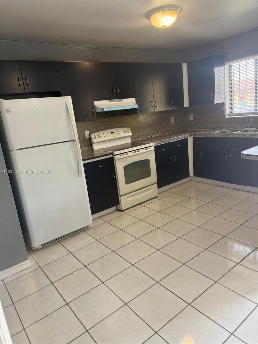 28144 Southwest 142nd Court Homestead, FL 33033 - Photo 12 of 12 a kitchen with stainless steel appliances granite countertop a stove a sink and a refrigerator