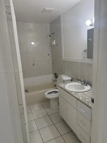 a bathroom with a granite countertop toilet a sink and bathtub