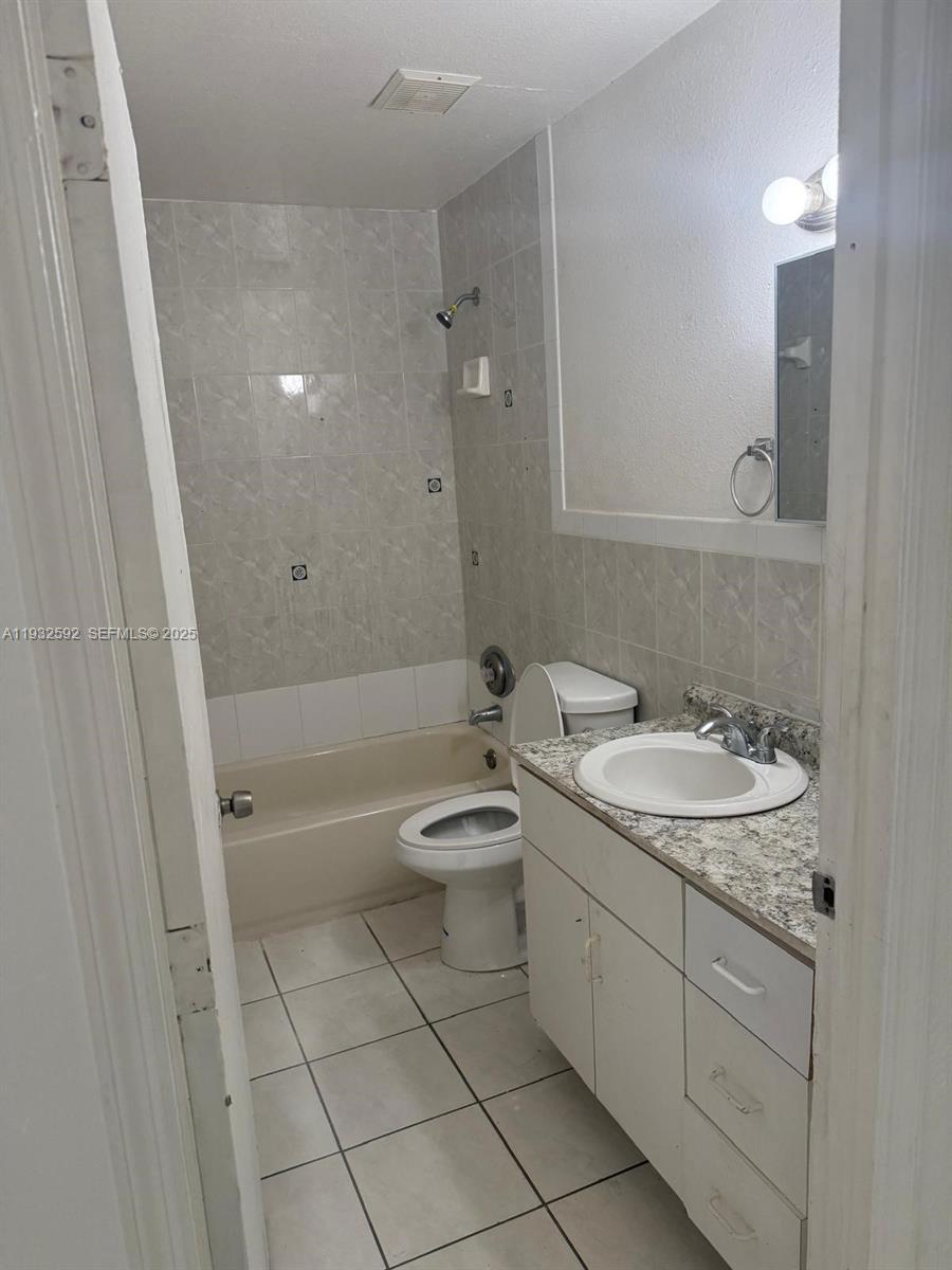 28144 Southwest 142nd Court Homestead, FL 33033 - Photo 6 of 12 a bathroom with a granite countertop toilet a sink and bathtub