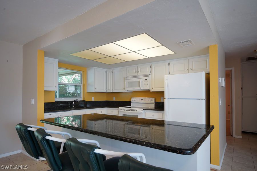 18557 Iris Road Fort Myers, FL 33967 - Photo 3 of 6 a kitchen with kitchen island a counter top space a sink stainless steel appliances and cabinets