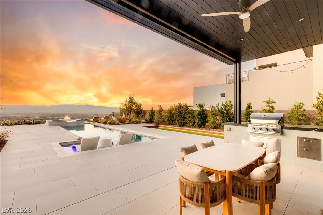 571 Overlook Rim Drive Henderson, NV 89012 - Photo 41 of 85 Patio terrace at dusk featuring ceiling fan, an outdoor kitchen / dining area, a patio area, and an infinity pool