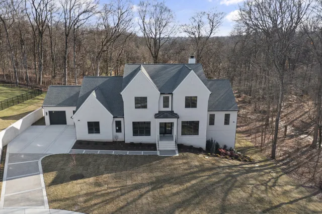 a view of a white house with a yard covered the snow