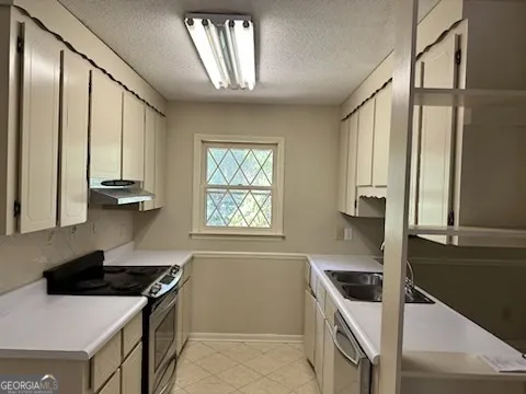 a kitchen that has a sink a stove and a window