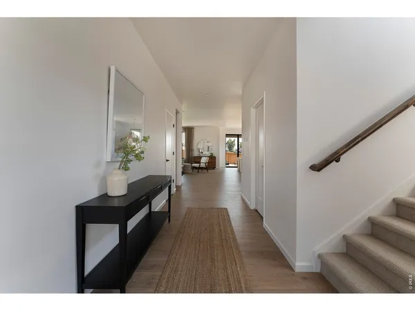 a hallway with wooden floor and furniture
