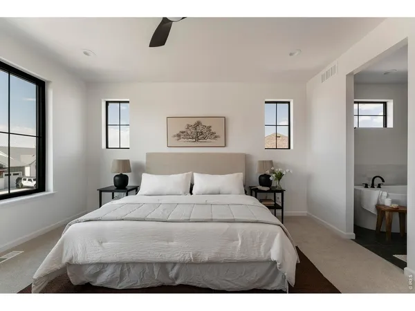 a bedroom with a bed a painting on the wall and a window