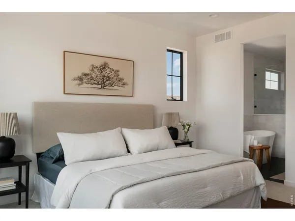 a bedroom with a bed and a painting on the wall