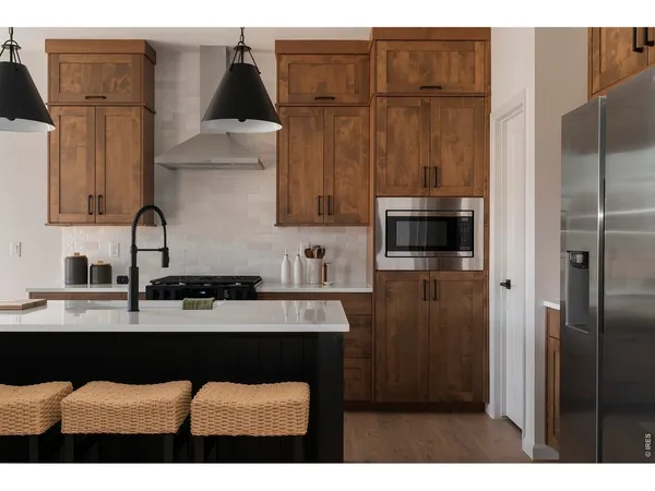 a kitchen with a sink refrigerator and cabinets