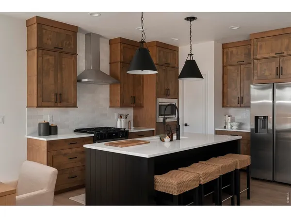 a kitchen with stainless steel appliances a sink a stove a refrigerator and cabinets