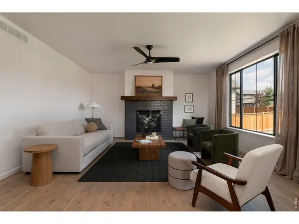 a living room with furniture a fireplace and a large window